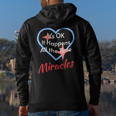 Gildan unisex zip-up hoodie with “Miracles Happen” design and uplifting message, Christian apparel made from soft cotton-poly fleece, ideal for cooler weather and faith-inspired comfort, man wearing black hoodie